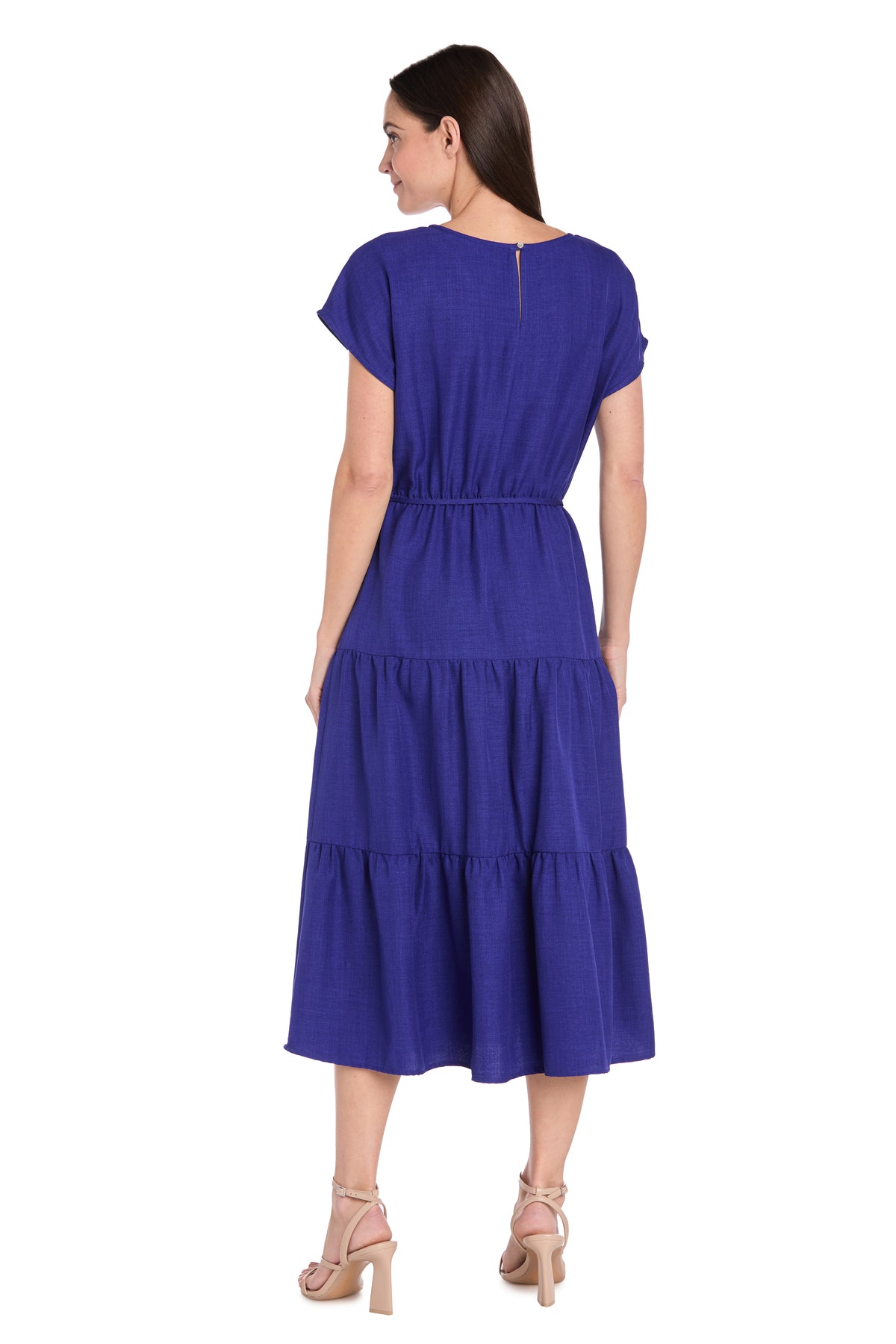 Woman shown from the back wearing the R&M Richards 6680 Tea-Length Blue Party Dress with short sleeves, tiered details, an elastic waist, and nude heeled sandals.